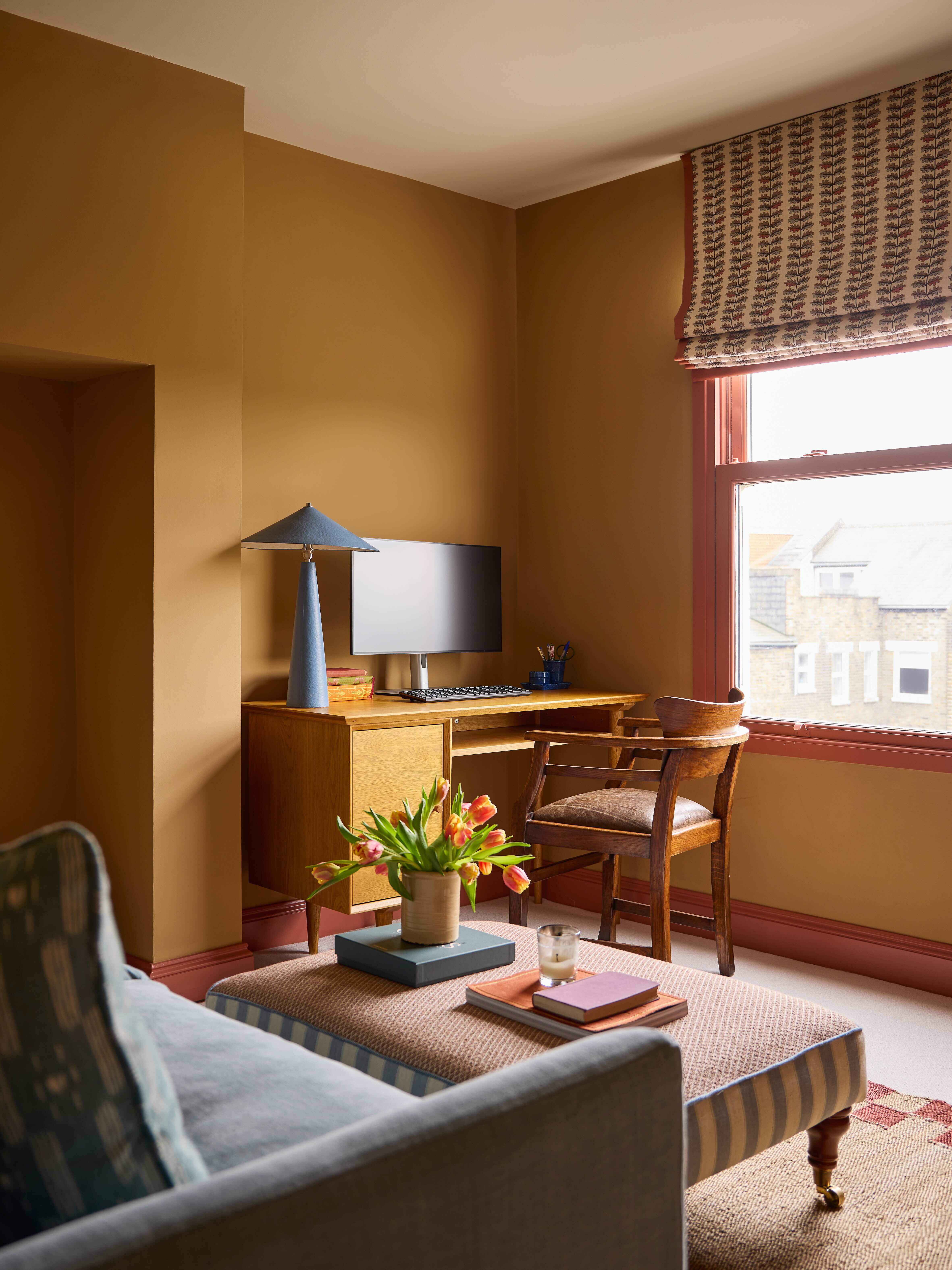 A home office painted in ochre with complementary terracotta trim