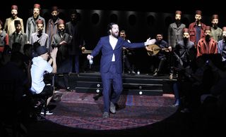 Catwalk transformed into a smoky Turkish gentlemen's club, featuring a collage of ottoman carpets.