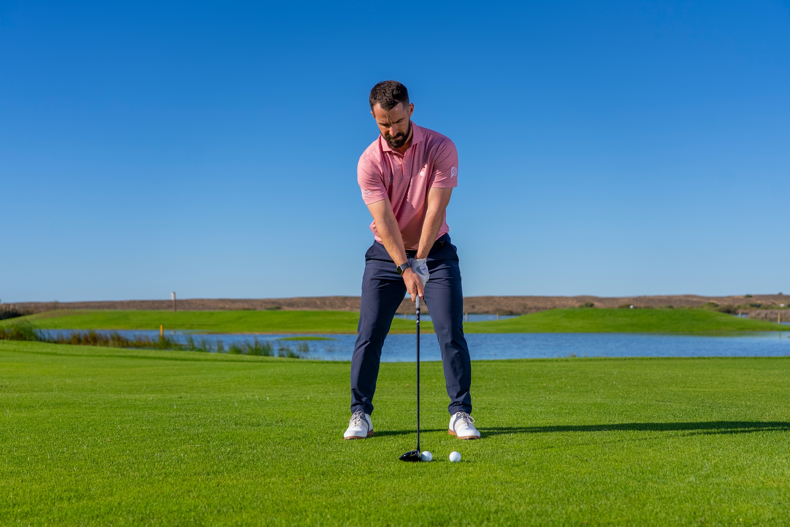 James Jankowski using two balls to represent the need for the club to glide through the grass past impact, as though you are trying to launch another ball in front too