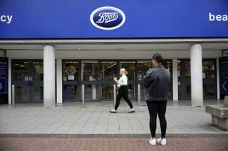 The front of a Boots store with two women standing outside