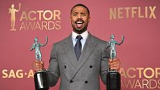 Michael B. Jordan holds up two Actor Awards
