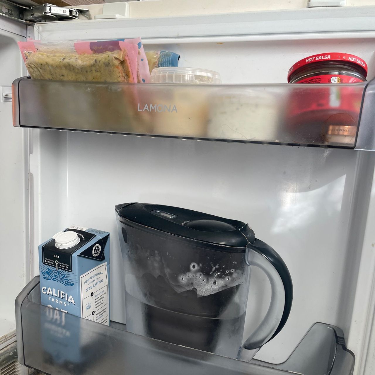 White fridge door with milk and food on the shelf
