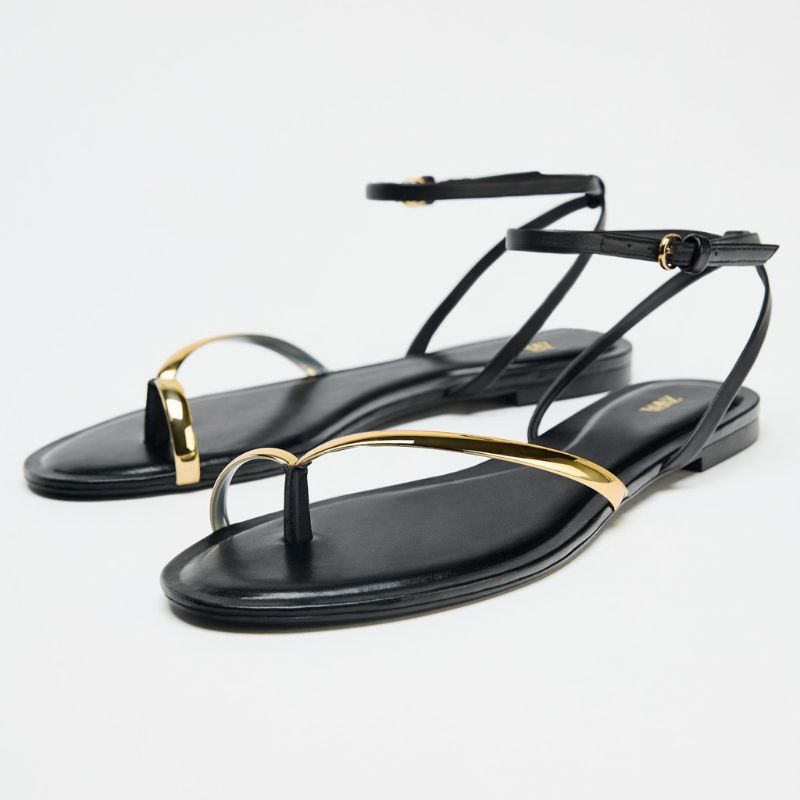 Cut out of black flat Zara sandals with metallic detailing