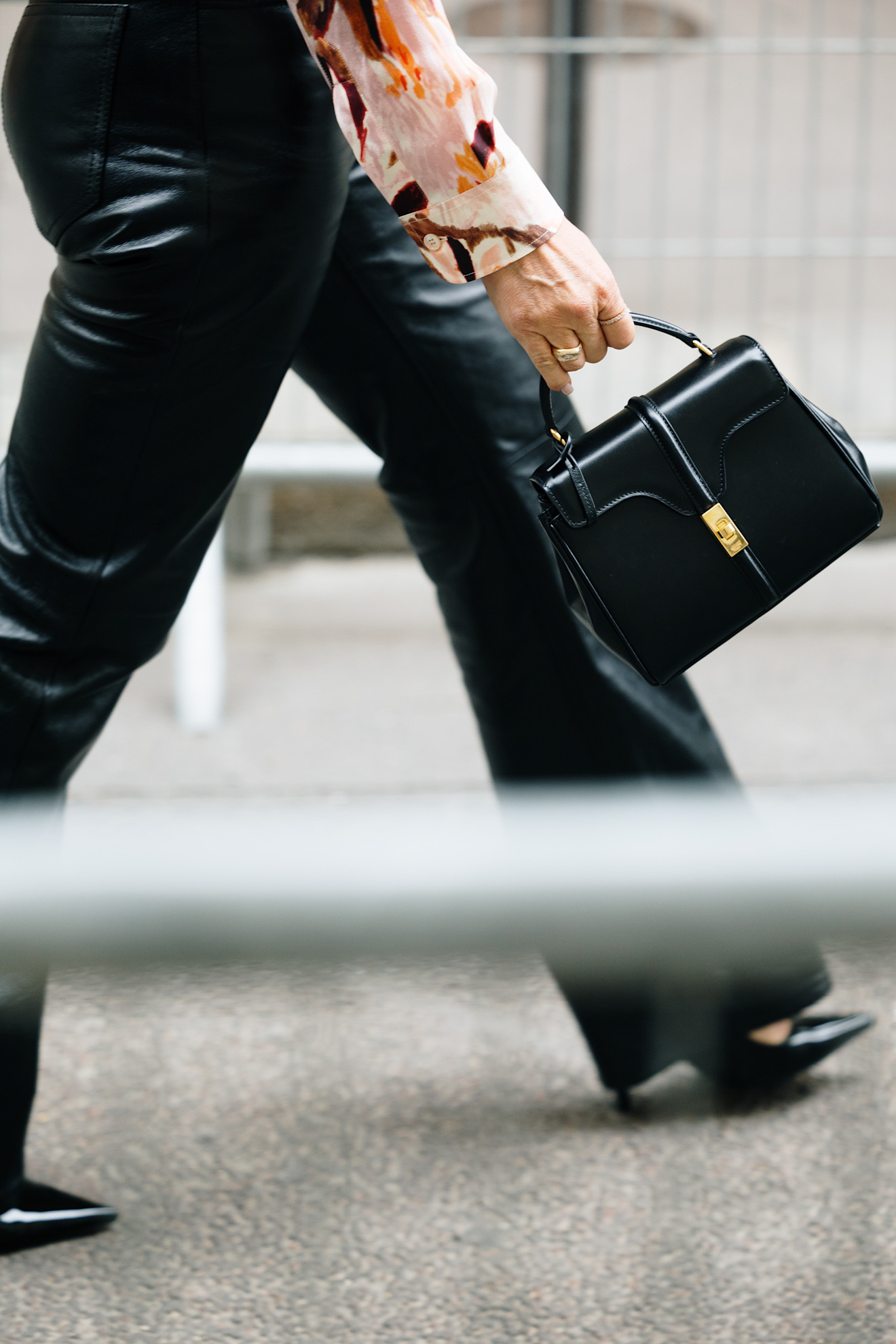 woman carrying a black top-handle bag