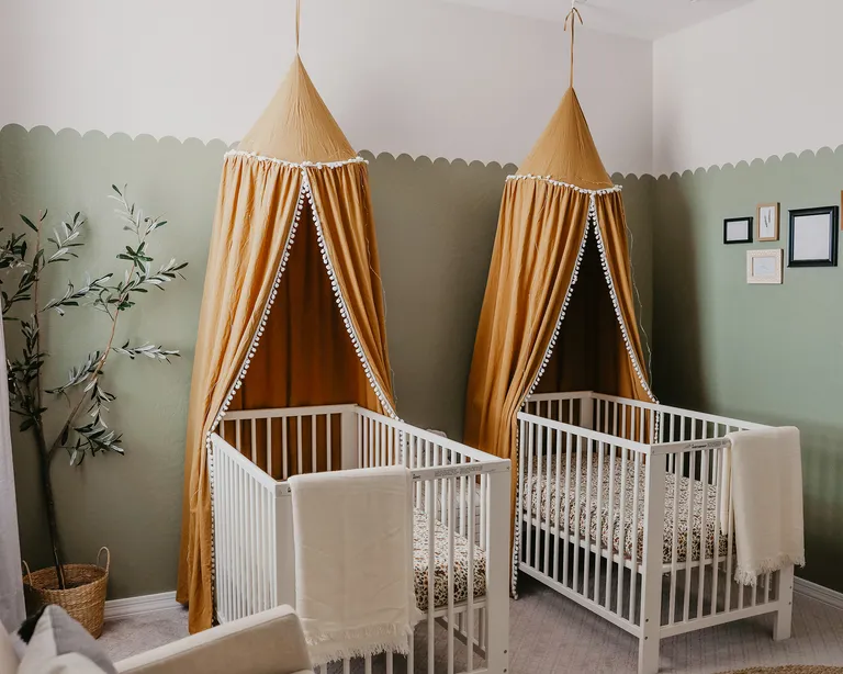Twin nursery ideas by Taylor Follett with rust orange canopies