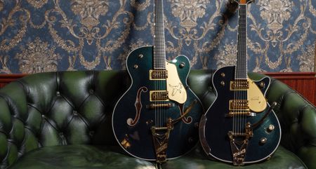 Gretsch G6136TG-58 Limited Edition 1958 Custom Falcon and G6134TG-58 Limited Edition 1958 Custom Penguin with Bigsby, photographed on a green leather couch,