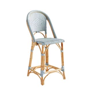 A light blue rattan chair with a curved back and light brown rattan legs