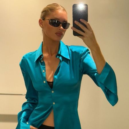 Influencer Elsa Hosk wears a blue satin shirt with a black pencil skirt