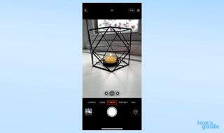 A screenshot of the iPhone camera app with a candle in the viewfinder