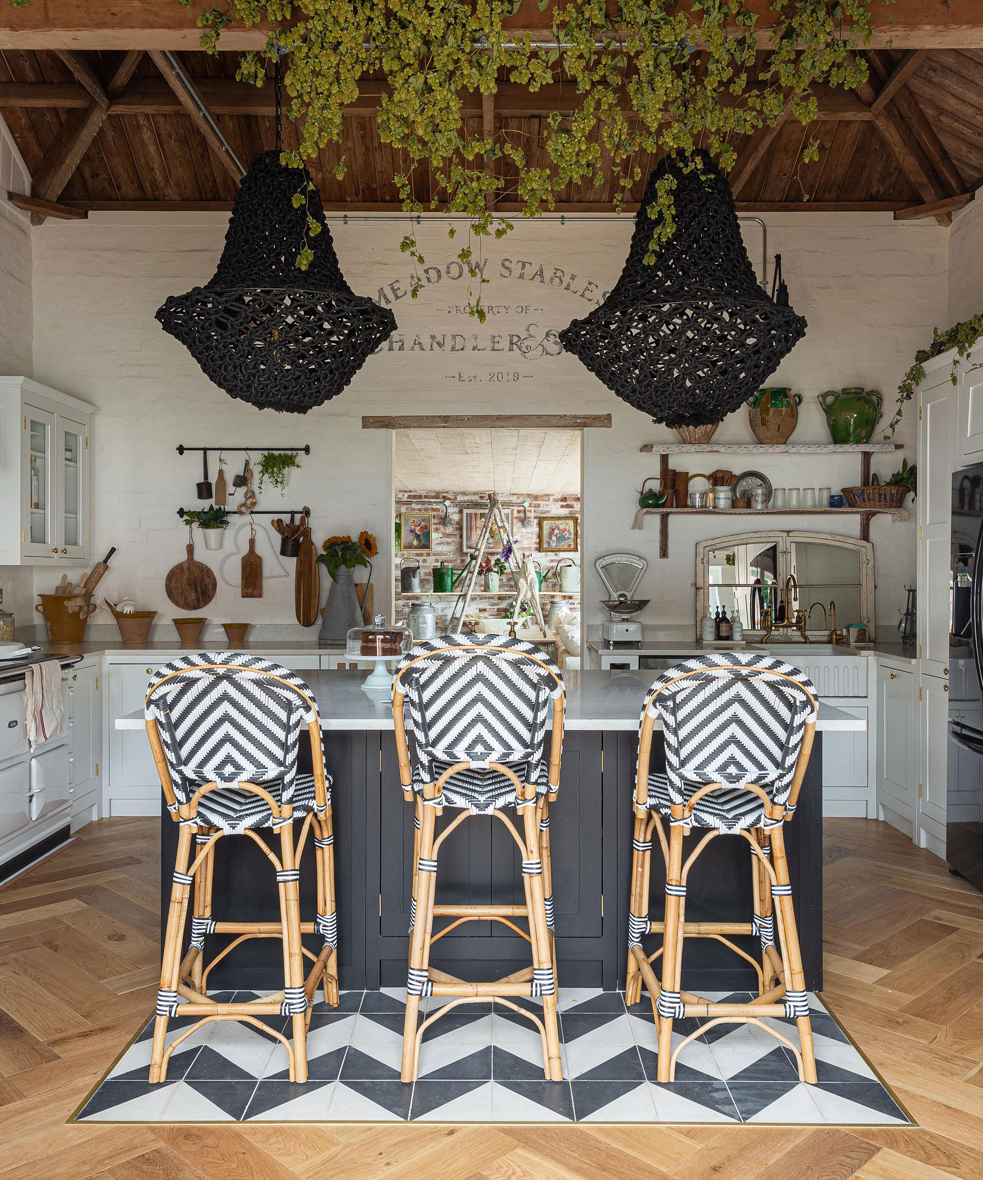 Kitchen trends 2021 showing monochrome tiles and bar stools with black pendant lighting