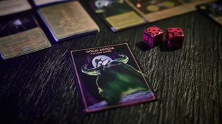 An Oogie Boogie villain guide alongside some dice on a wooden table