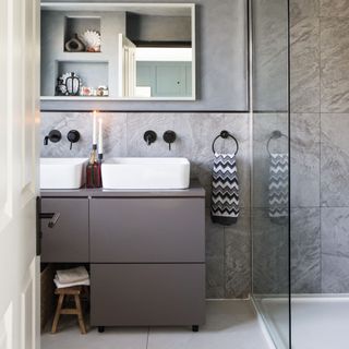 en suite bathroom with grey tiles and double basin