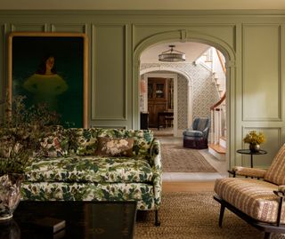 a sage green living room with a floral patterned couch