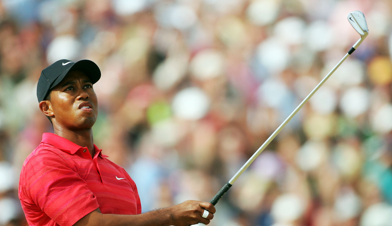 Tiger Woods hits an iron shot and watches its flight