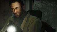 Nick shines the flashlight attached to his rifle toward the camera in Left 4 Dead 2.