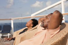 Couple on chairs on deck of cruise ship