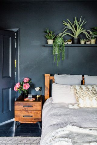 dark black/blue painted bedroom with white bedding