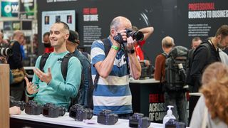 Attendees inspect cameras as the Photography Show 2021