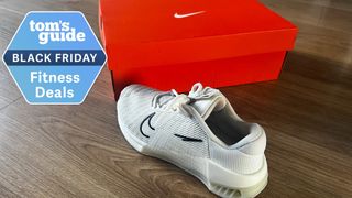 Nike Metcon 9 shoe in white next to box and Black Friday deals badge top left
