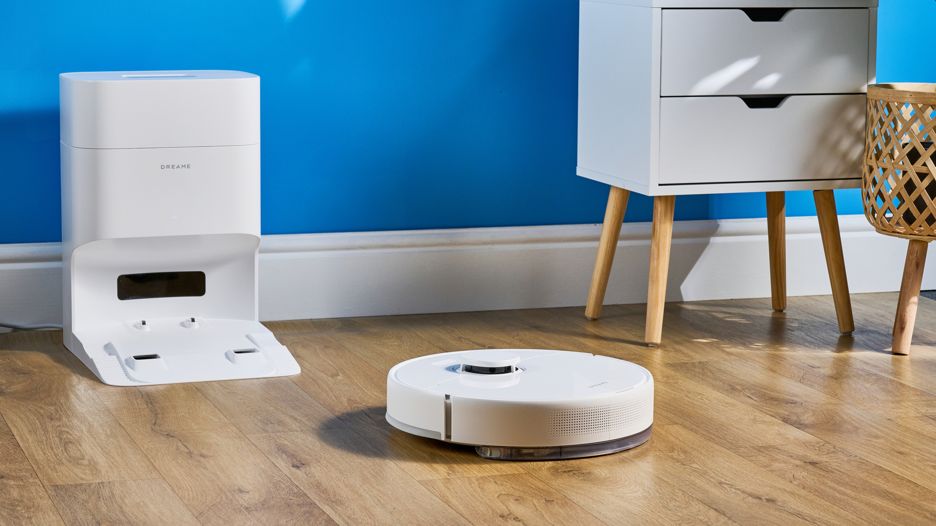 Dreame D10 Plus Gen 2 photographed on a wooden floor in front of a blue backdrop