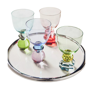 4 multicolored glasses on round serving tray