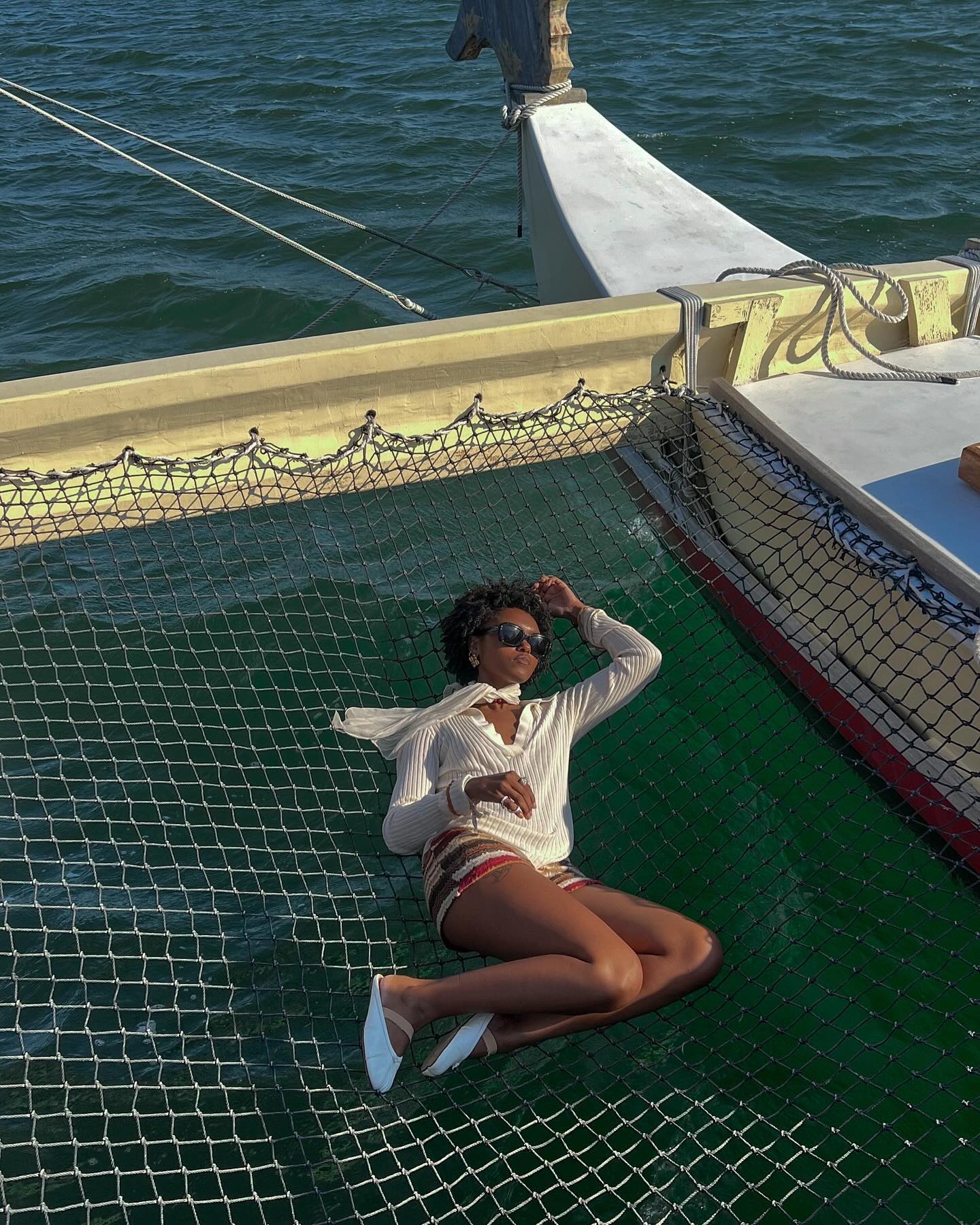 Content creator Destiny Joseph lying on a net aboard a boat.