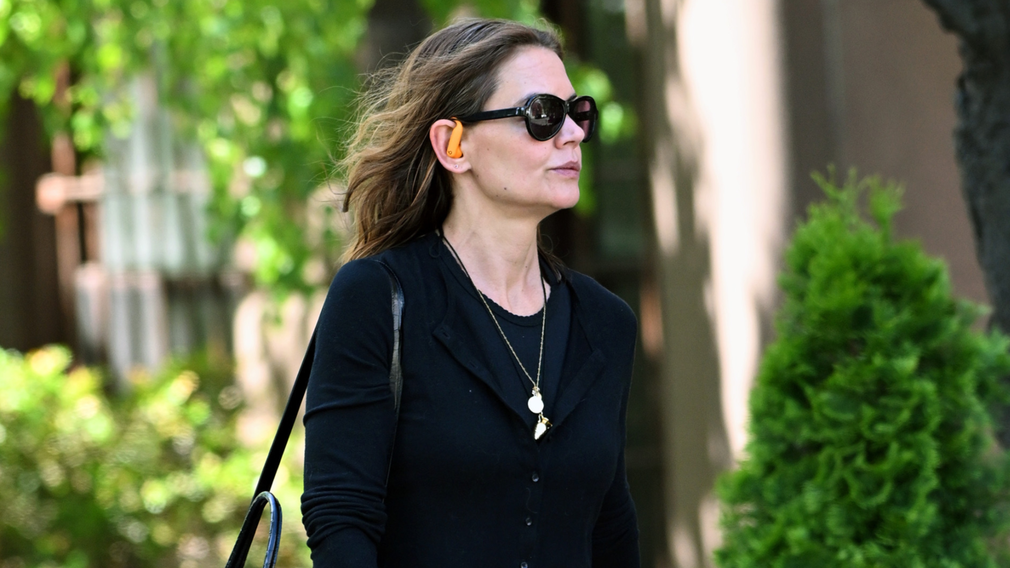 Katie Holmes wearing a black cardigan and a cord necklace