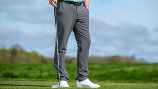 A golfer wears the Callaway Chevron Tech Pant in grey