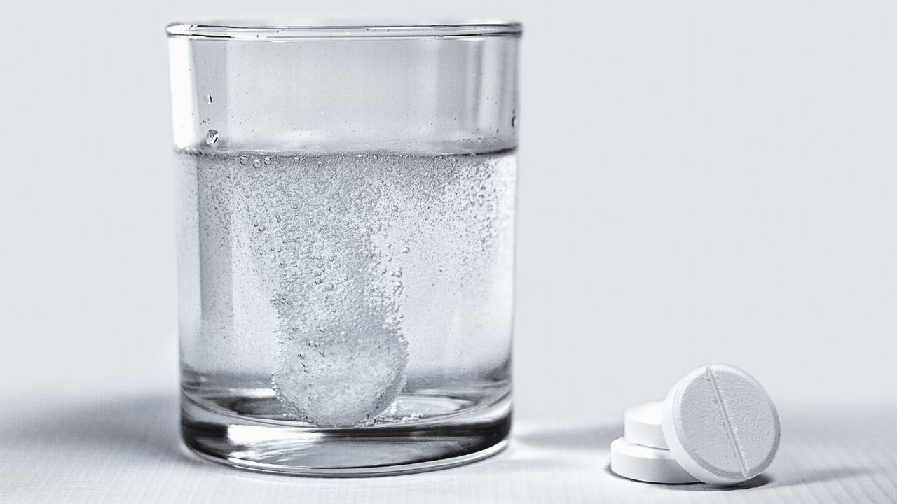 A denture tablet fizzing in a glass