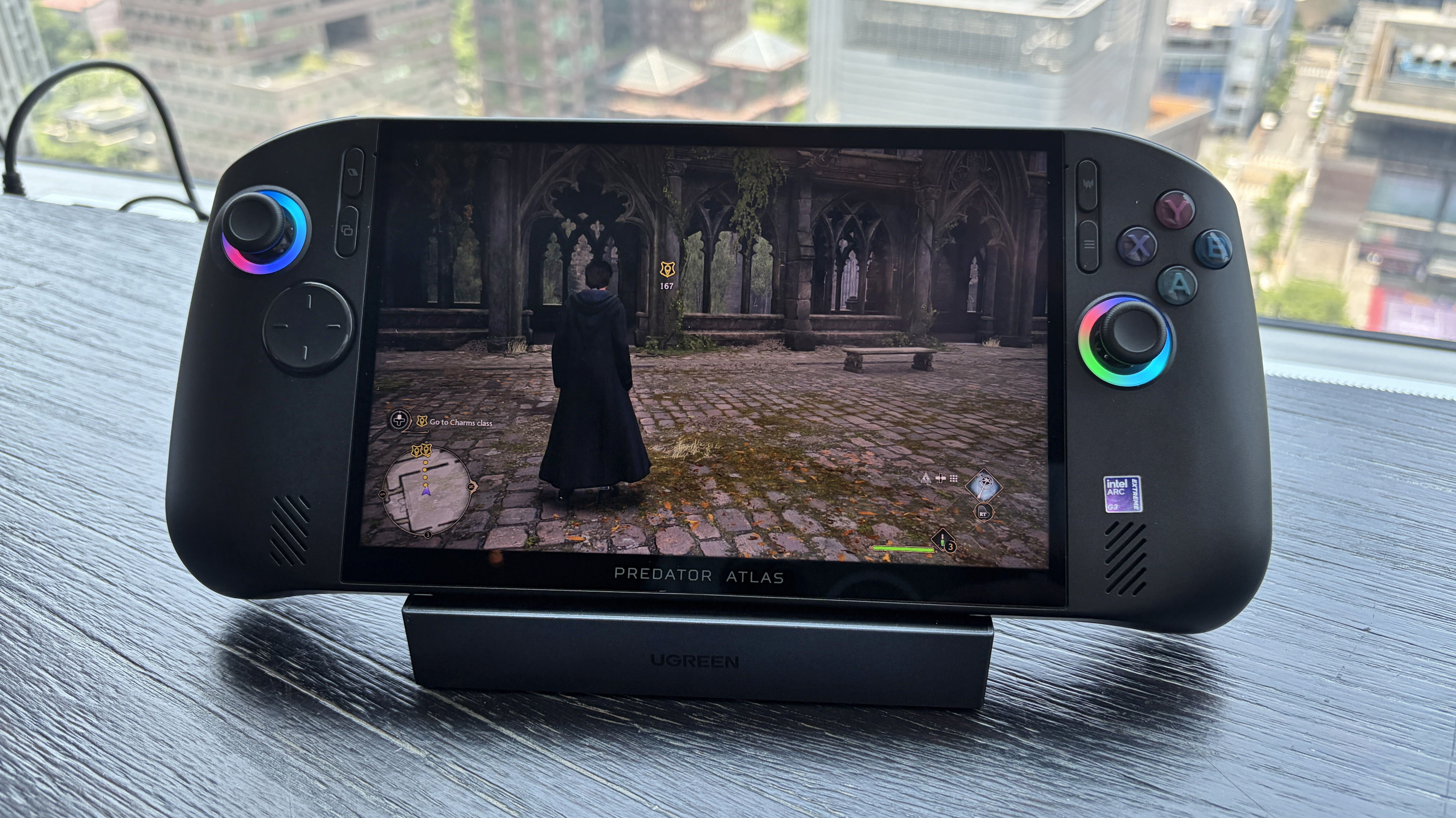 Acer Predator Atlas 8 handheld gaming device on stand displaying Hogwarts Legacy with a cloaked character.