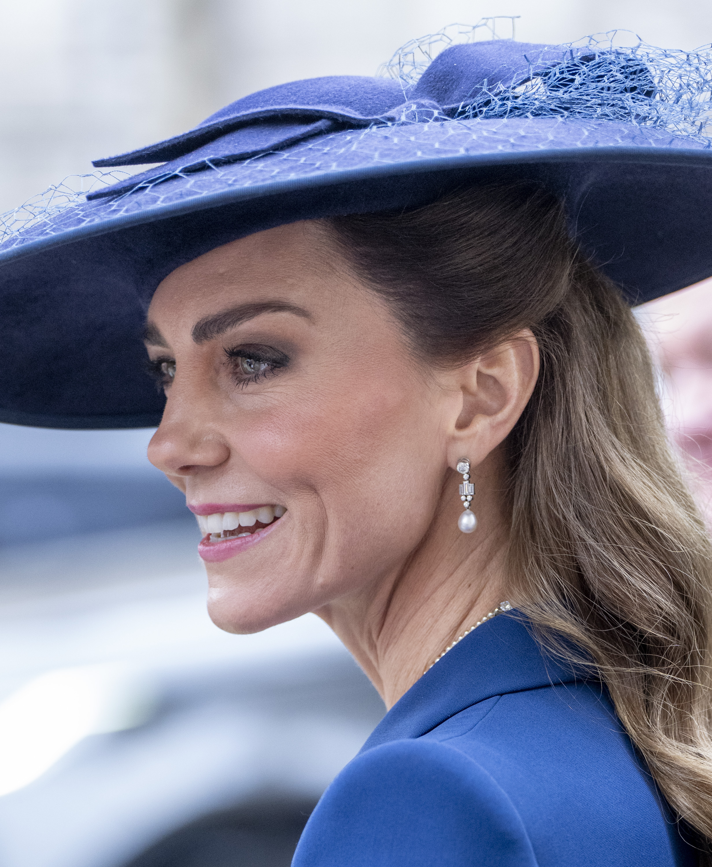 Princess Kate wearing a blue hat and coat smiling