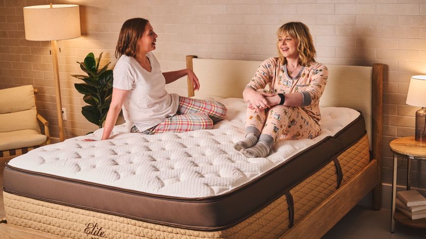 Tom&#039;s Guide mattress testers sitting on a Helix Midnight Elite mattresswith GlacioTex cover in a luxurious bedroom 