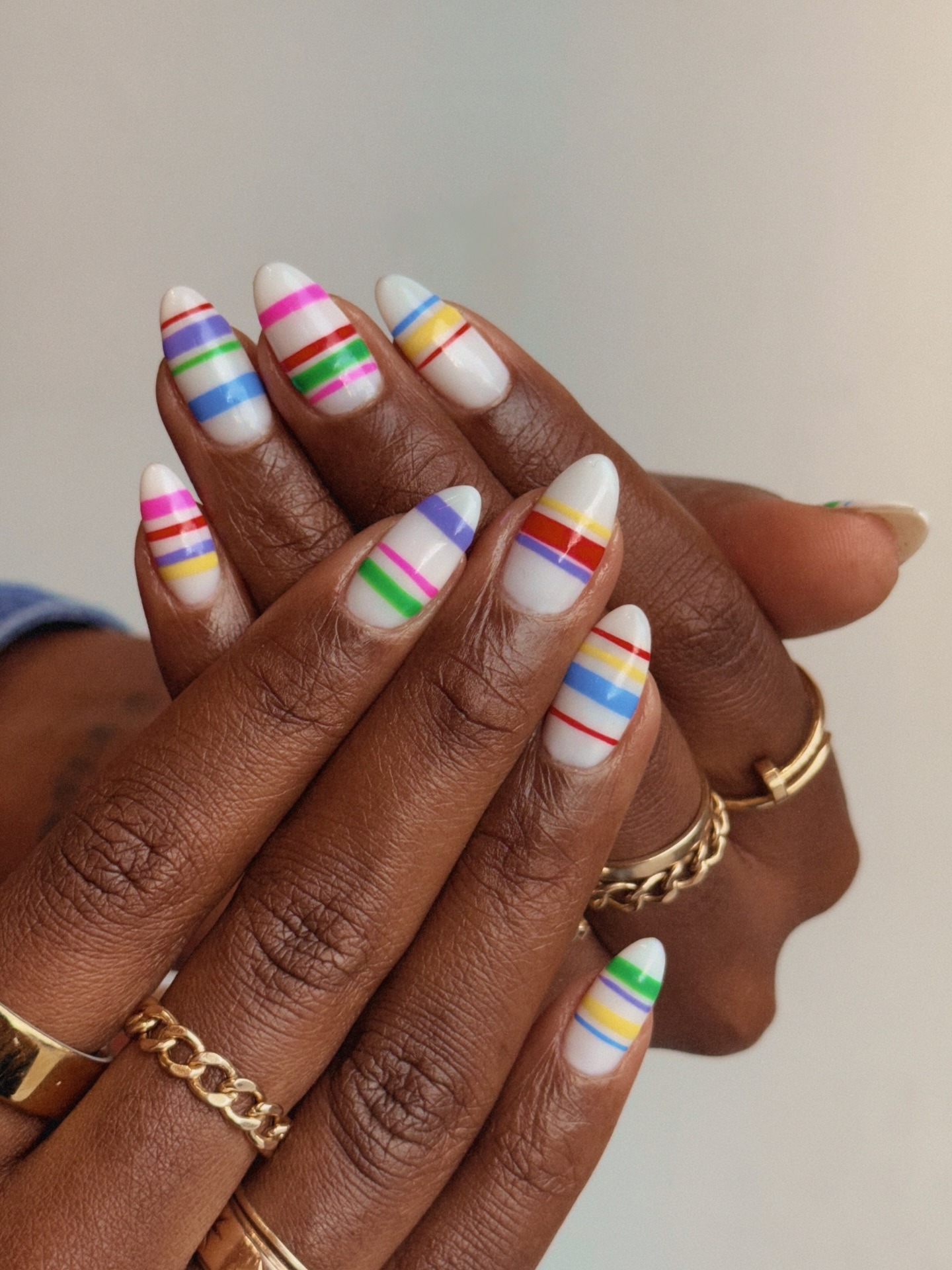 A white manicure with colourful stripes
