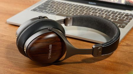 A close-up, angled view of the SIVGA SV021 Pro headphones resting on a wooden desk, highlighting the dark wood earcups and the silver "SIVGA" logo.