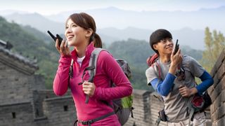 Young couple hiking and using the best walkie talkies