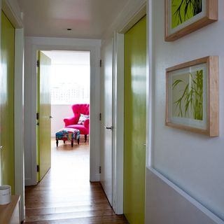 hallway with frames on wall and green door