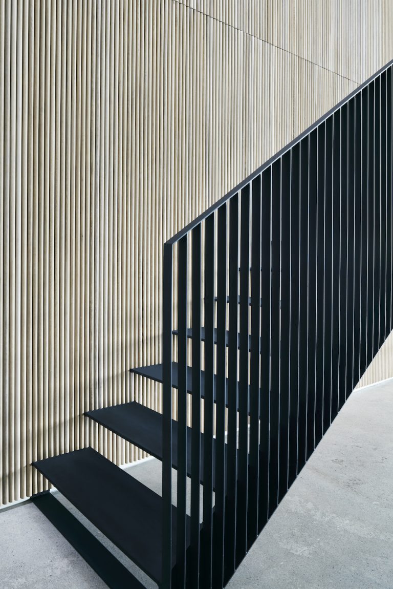 steel staircase against wood wall