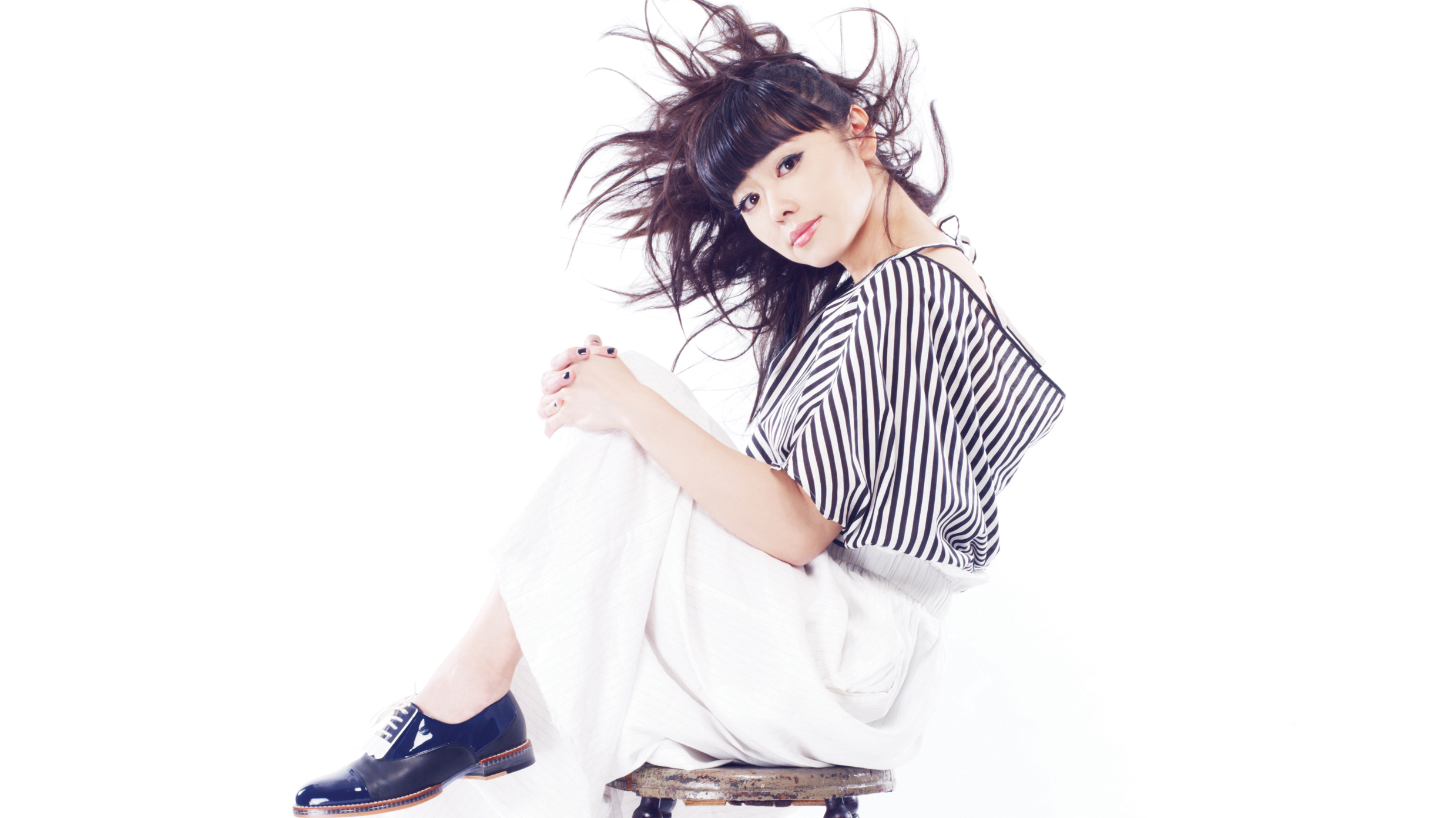 Hiromi sitting on a chair with a striped top