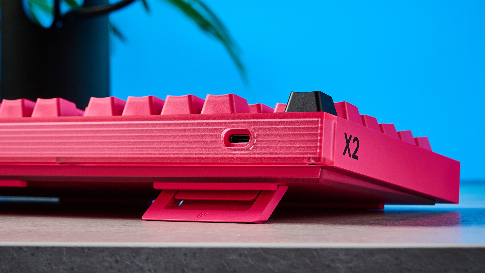 A photo of the Logitech G Pro X2 Rapid keyboard in hot pink on a stone surface