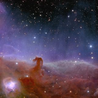 A hazy view of dust and gas in the cosmos. At the bottom, some of the material makes a hooked shape.