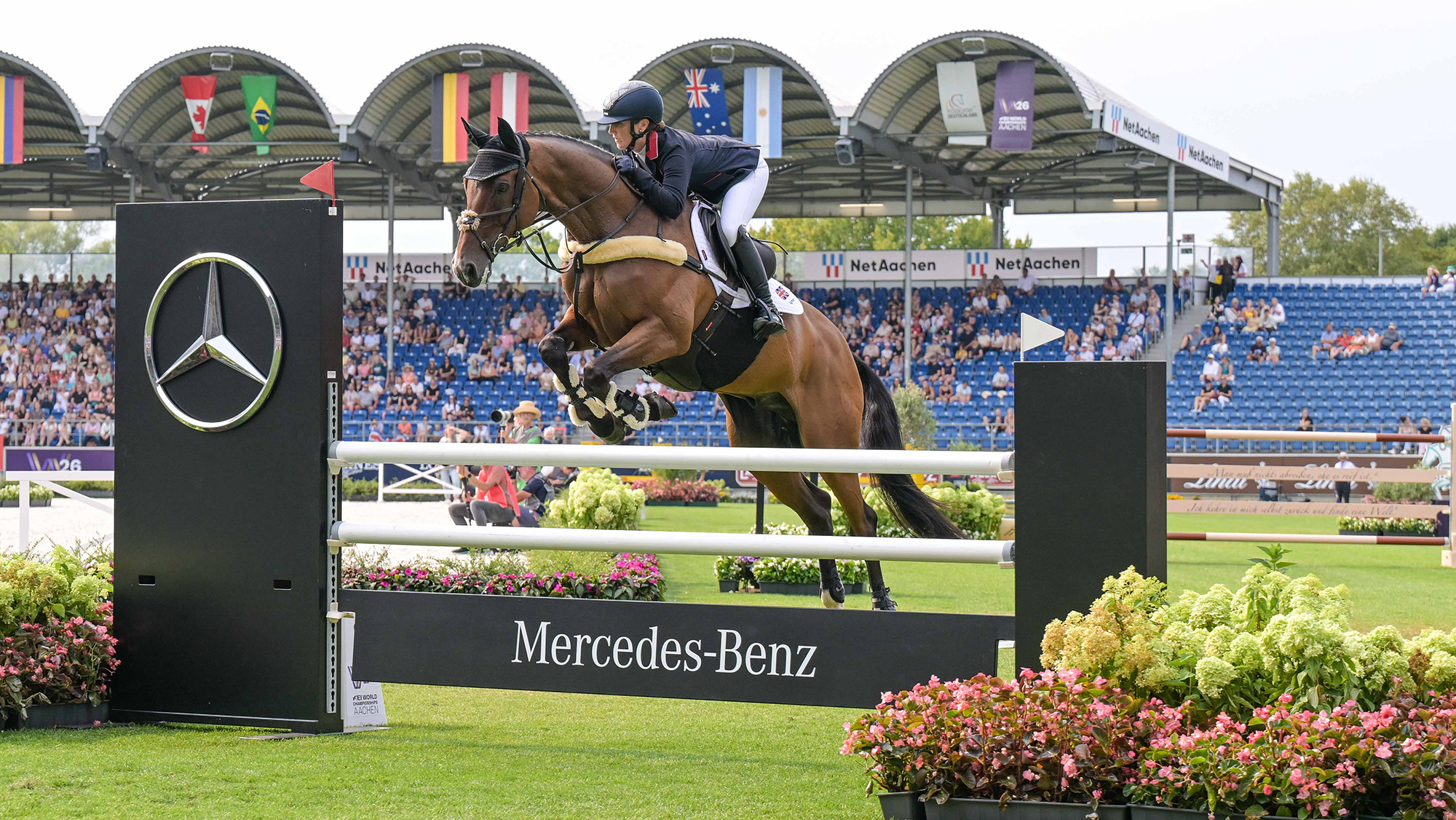 London 52 clears an upright black and white Mercedes Benz branded showjumping in the main arena at Aachen world eventing championships.