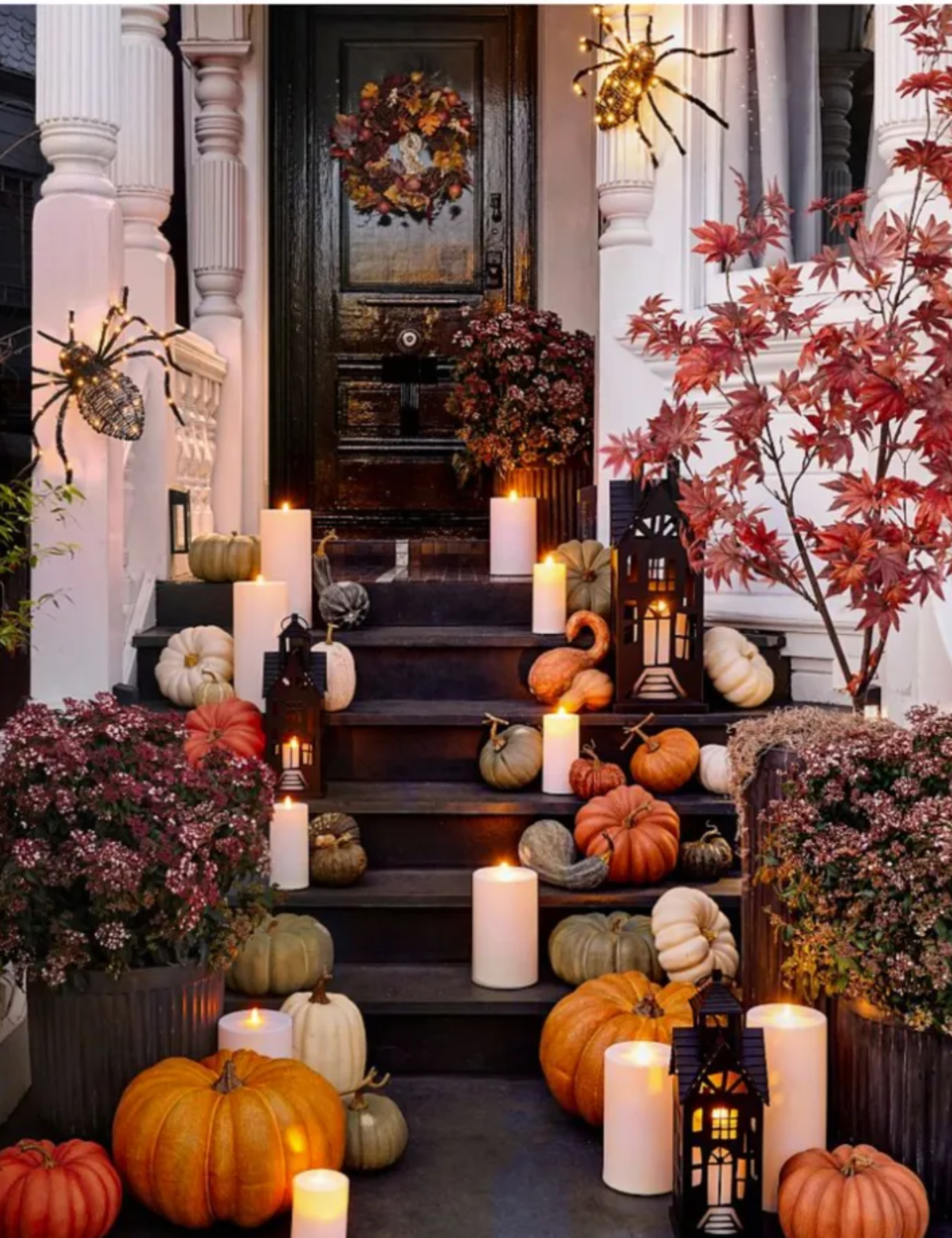 Porch steps decorated with pumpkins and candles