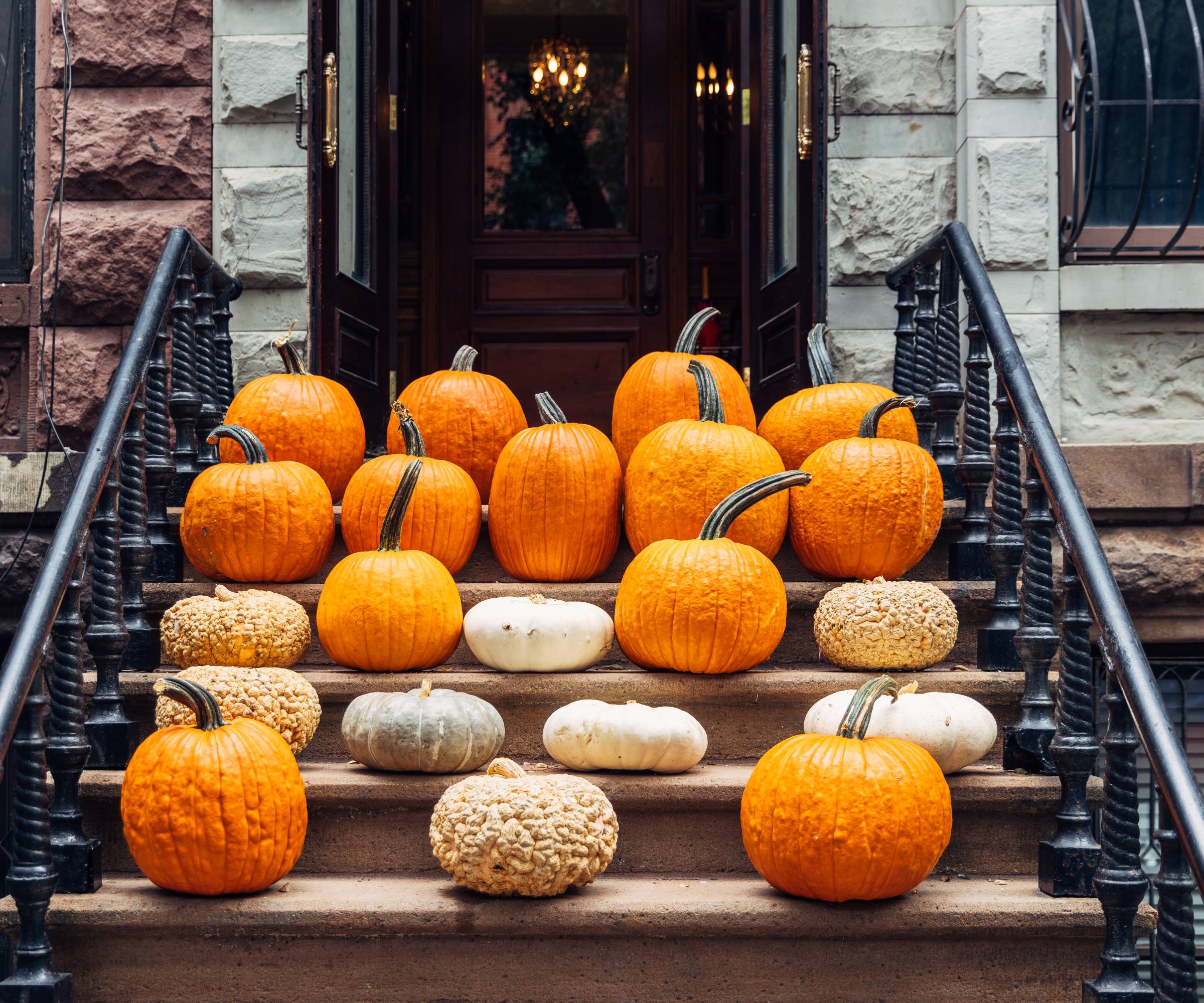 Lots of pumpkins on the front steps of a building