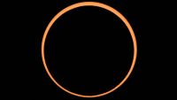 Annular solar eclipse appears as an orange ring of light around a black circle (the moon) against a black background. 