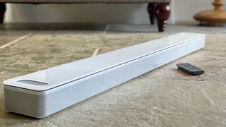 Bose Smart Ultra Soundbar in white placed on a stone floor