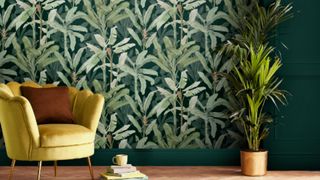 Bright green nature inspired wallpaper, with a yellow chair against it to illustrate the forest green color trend