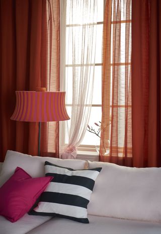Orange curtains with pink dotted sheer curtains from Ikea