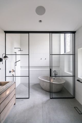 A bathroom with metal and glass partition