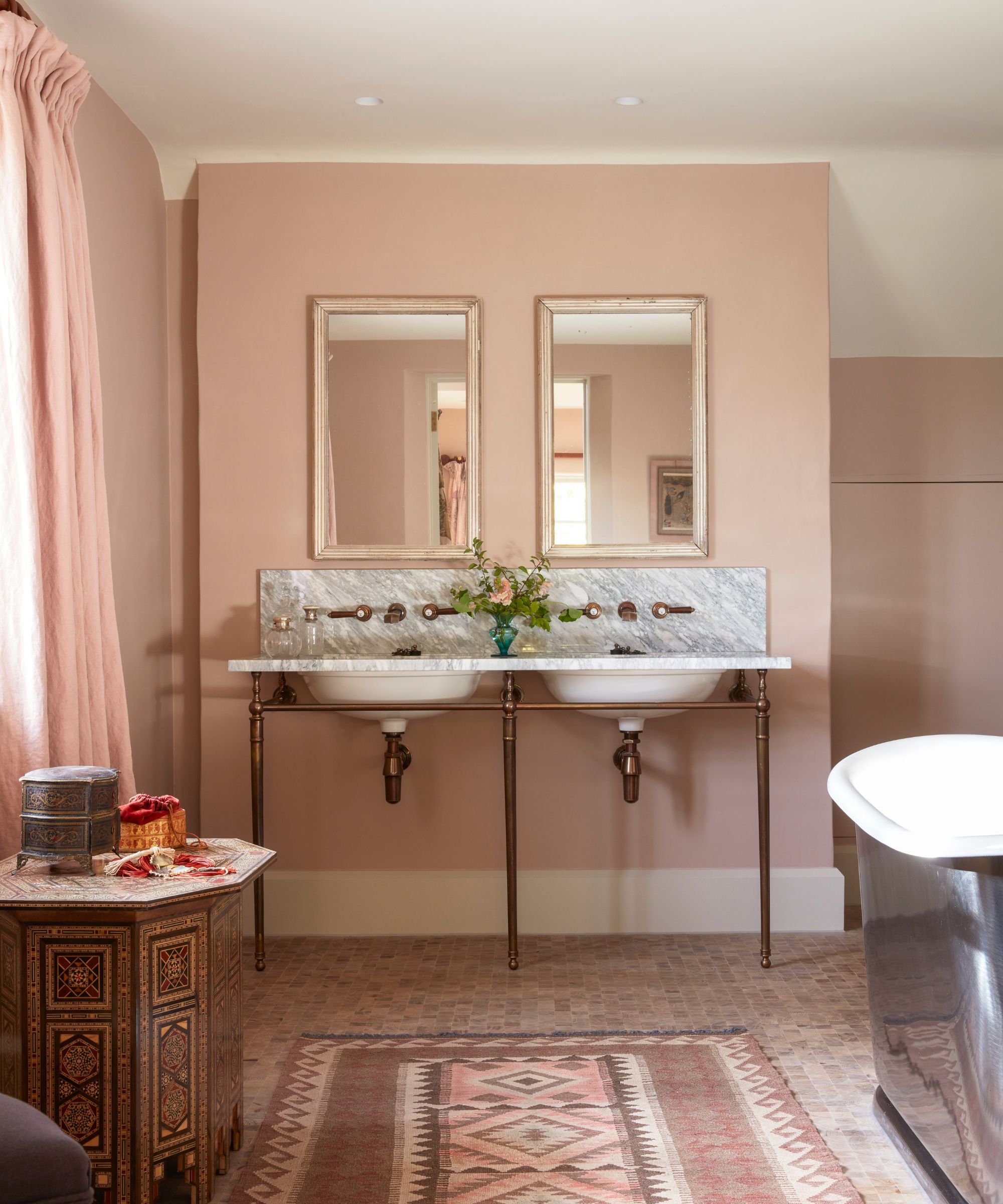 Pink bathroom with double sink and patterned rug