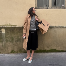 Lucy McFadin wearing a trench coach and glasses with a grey top.
